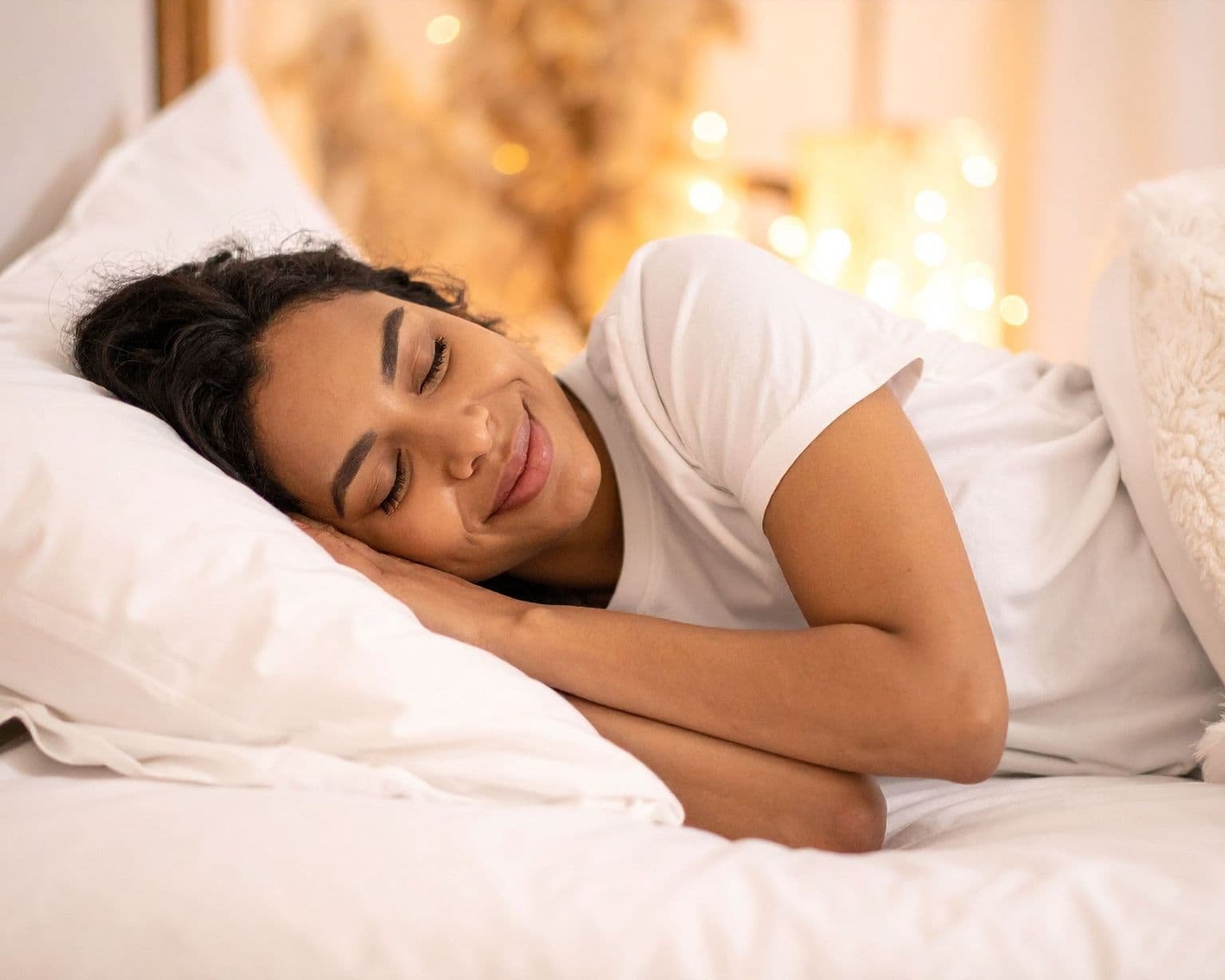 Mujer relajada preparándose para dormir en una habitación acogedora con luz cálida, representa bienestar y descanso natural con aceites esenciales – Un Aceite Para Eso