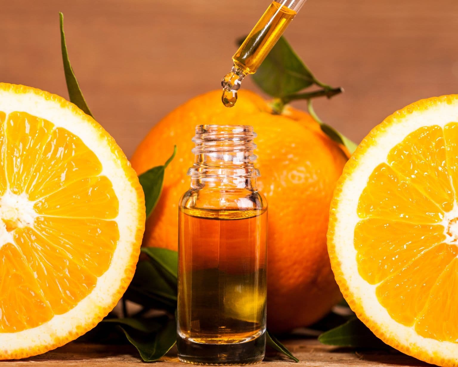 Aceite esencial de Naranja con cáscaras frescas mostrando sus beneficios aromáticos y de bienestar