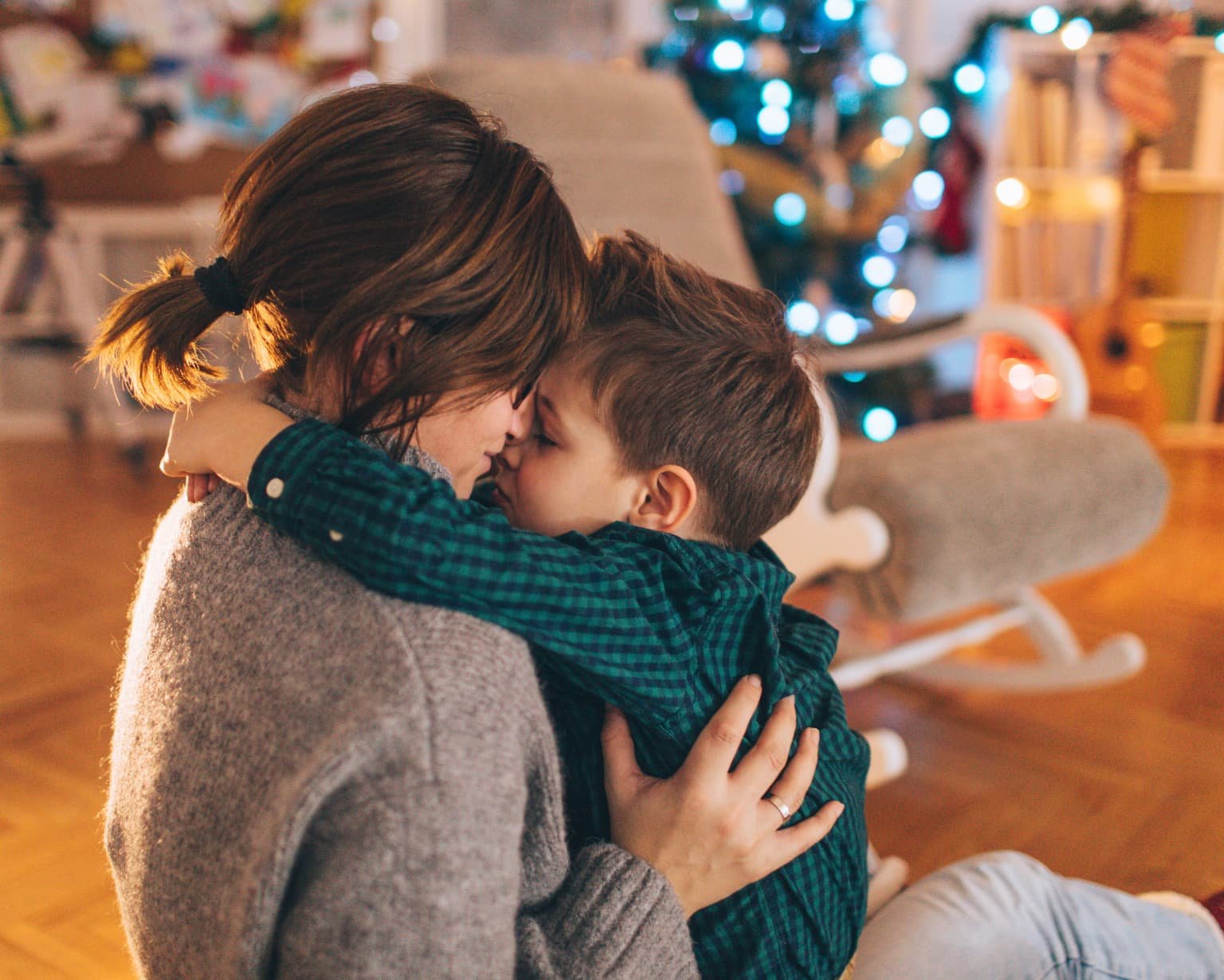 Mamá y su hijo en un ambiente invernal acogedor, representando el bienestar y la calidez que se pueden crear al iniciar con aromaterapia durante el invierno.